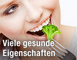 Frau isst Brokkoli