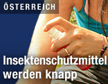 Frau schützt sich mit Insektenschutzmittel