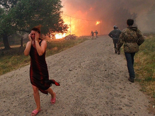 © Reuters/Mikhail Voskresenskiy Verzweifelte Frau mit Brand im Hintergrund