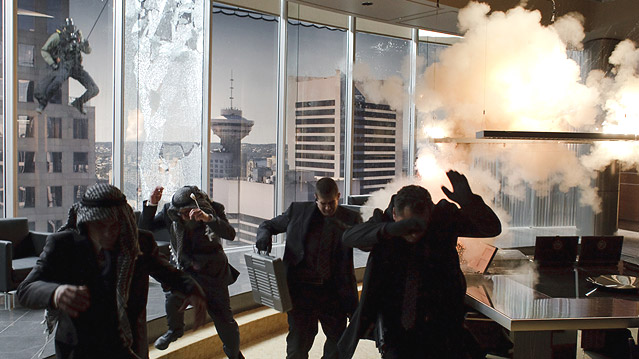 © 2010 Twentieth Century Fox Ein Sonderkommando springt durch ein großes Bürofenster, Männer flüchten.