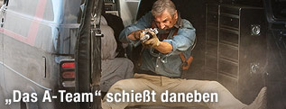 Schauspieler Liam Neeson als John "Hannibal" Smith schießt aus einem fahrenden Van.