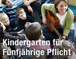 Kindergruppe und Betreuerin mit Gitarre