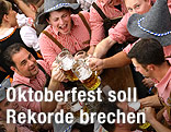 M&auml;nner in Tracht trinken Bier auf dem M&uuml;nchner Oktoberfest.