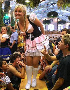 Eine Frau im Dirndl steht auf einem Tisch im Hofbräu-Festzelt am Münchner Oktoberfest.