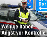 Polizisten vor einem Einsatzfahrzeug
