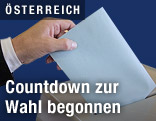 Stimmzettel wird in Wahlurne geworfen