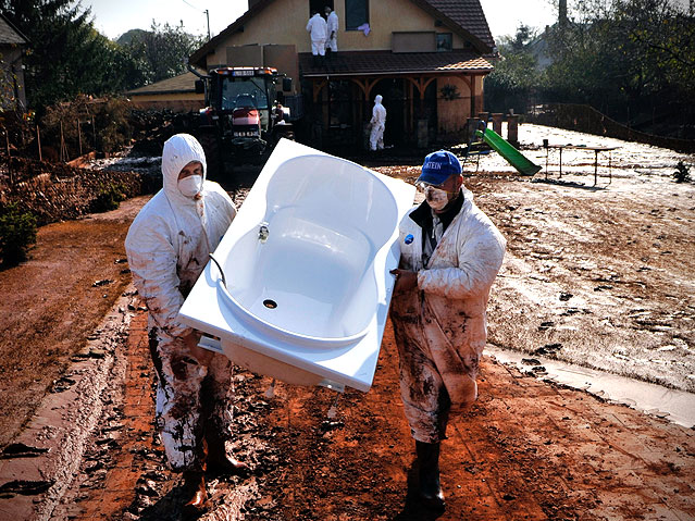© AP/Bela Szandelszky Helfer in Kolontar tragen eine Badewanne