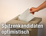 Jemand wirft Wahlzettel in Urne