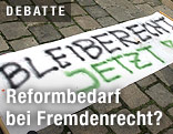Ein Transparent auf Kopfsteinpflaster mit der Aufschrift "Bleiberecht jetzt!"
