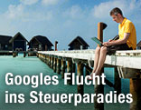 Mann mit Laptop am Strand