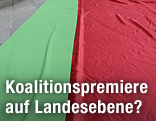 Gr&uuml;ne und rote Stoffabahnen liegen am Boden