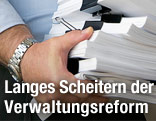 Mann hält Stapel von Papier