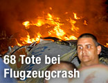 Rettungskräfte vor brennendem Flugzeugwrack