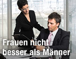 Eine Frau zeigt ihrem männlichen Kollegen im Büro Unterlagen