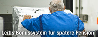 Älterer Arbeiter schiebt Kiste