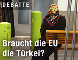 Frau mit Kopftuch sitzt auf Bank
