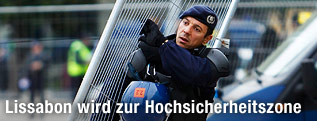 Ein portugiesischer Polizist trägt eine Absperrung