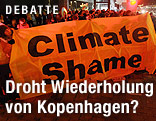 Demonstranten halten Plakat mit der Aufschrift "Climate Shame"
