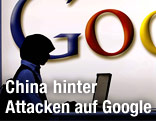 Unbekannter sitzt mit Computer vor Google-Logo