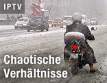 Motorradfahrer auf einer schneebedeckten Stra&szlig;e