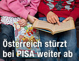 Zwei Kinder lesen in einem Buch