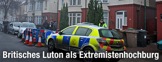 Polizisten stehen vor einem Haus in Luton, England