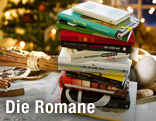 Ein Stapel B&uuml;cher liegt auf einem weihnachtlich geschm&uuml;ckten Tisch