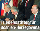 Der serbische Präsident Slobodan Milosevic, der kroatische Präsident Franjo Tudman und der bosnisch-herzegowinische Präsident Alija Izetbegovic bei der Unterzeichnung des Dayton-Vertrags