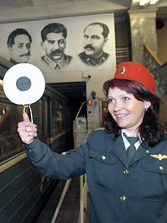 © APA/EPA/Vassili Grachyov Mitarbeiterin der Moskauer Metro neben einem fahrenden Zug