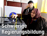 Zwei Personen in einem Wahllokal im Kosovo