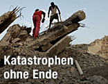 Arbeiter entfernen Schutt auf einem von Erdbeben zerstörten Haus