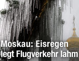 Eiszapfen h&auml;ngen von Fenster in dem sich der Turm einer Kathedrale spiegelt