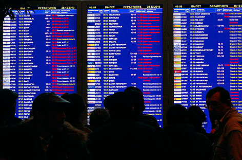 Passagiere vor einer Anzeigetafel für Abflüge