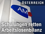 AMS-Logo vor Eingang zu Arbeitsamt