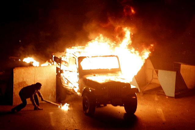 © AP/Xinhua/Cai Yang Demonstrant setzt Militärjeep in Brand