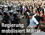 Ägyptische Polizisten und Demonstranten stehen sich in Kairo gegenüber