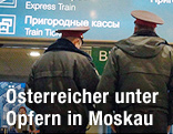 Polizisten vor der Fluganzeigetafel am Flughafen von Moskau