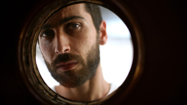 Schauspieler Edoardo Gabbriellini sieht durch ein rundes Fenster.