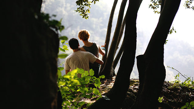 Die Schauspieler Tilda Swinton und Edoardo Gabbriellini sitzen in einem Wald.