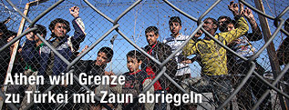 Immigranten hinter einem Zaun
