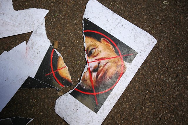 Ein zerrissenes Poster von Hosni Mubarak liegt auf der Straße.