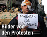 Ein am Kopf bandagierter Ägypter hält ein Schild mit der Aufschrift "Mubarak is crimenal".