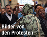 Ein Soldat versucht Demonstranten aufzuhalten