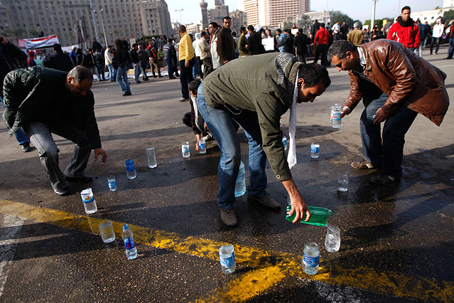 © AP/Khalil Hamra Männer füllen Wasserflaschen am Tahrir Platz in Kairo.