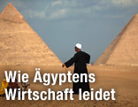 Kameltreiber steht vor Pyramiden