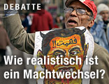 Mann hält Zeichnung von Mubarak als Teufel hoch