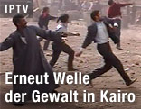 Männer werfen mit Steinen