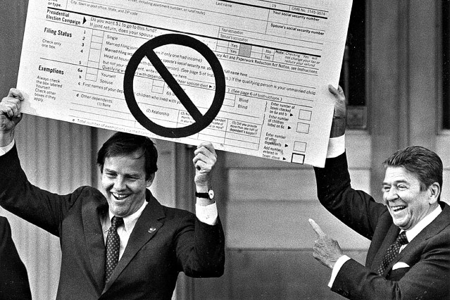 © AP Thomas Kean, Gouverneur von New Jersey, und der ehemalige US-Präsident Ronald Reagan halten eine übergroße Replik eines Steuerformulars