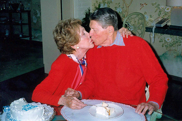 © AP Ehemaliger US-Präsident Reagan und seine Frau Nancy küssen sich zu seinem 89. Geburtstag