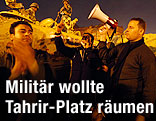 Demonstranten mit Megaphone im Hintergrund Milit&auml;t